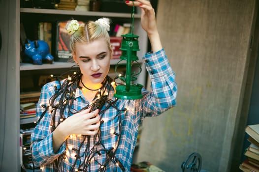 Portrait of a young woman with lights. beautiful girl with white hair dyed, holding christmas lights