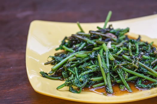 Fried vegetable fern in oyster sauce on table