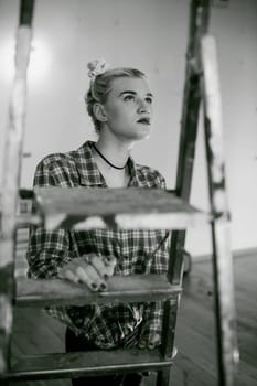 girl and construction ladder. studio shot of a young woman with a construction ladder in the room