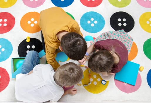 Children playing together with a play on the carpet and having fun together