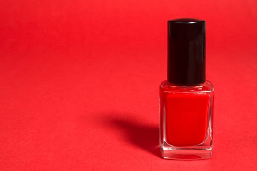 Red nail polish on the red background.