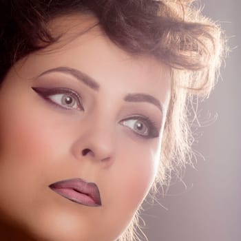 Beautiful female face with perfect complexion and glamorous retro make-up.