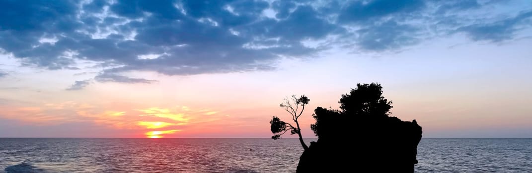 Dramatic sunset over the Adriatic Sea with Kamen Brela - Tiny famous island in Brela, Makarska Riviera, Croatia