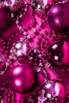 Pink and purple Christmas decoration on pink background.