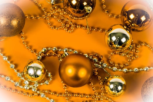 Golden or orange Christmas decoration on yellow background.