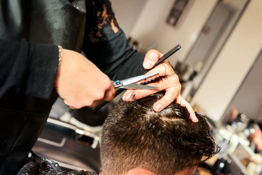 Hairdresser doing haircut in hairdressing salon