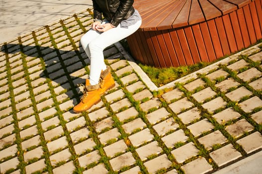 Portrait of young woman walking outdoors on warm autumn afternoon. Sitting resting