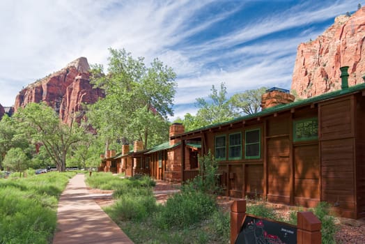 Springdale, Utah, USA - June 3, 2015: Zion Lodge at Zion National Park near Springdale, Utah. Tourists are resting on the cool grass and under the trees at the Lodge. Zion Lodge is the only accommodation in a park and is nestled deep in Zion Canyon with a gift and souvenir shop and easy access to hiking trails.