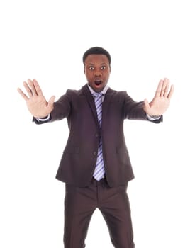 An African business man holds his hands up and mouths open and.says NO, don't do this, isolated for white background.