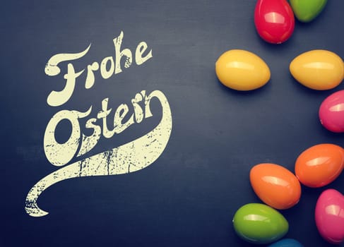 Colorful plastic Easter eggs on a chalkboard with space for text or image