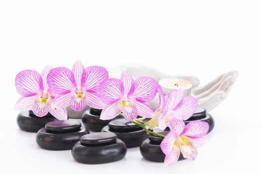 Spa with hot stones and candle on a palm shaped candle holder close up