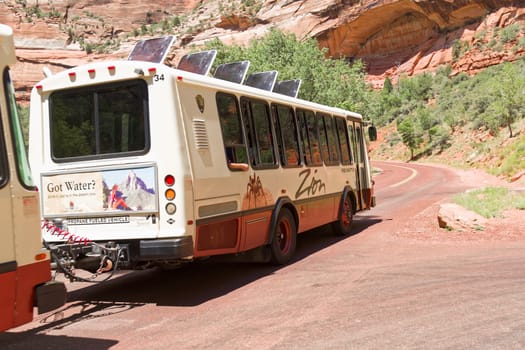 Springdale, Utah, USA - June 3, 2015: Zion Park Bus transports tourists inside the park at the Lodge. Zion National Park, Utah.