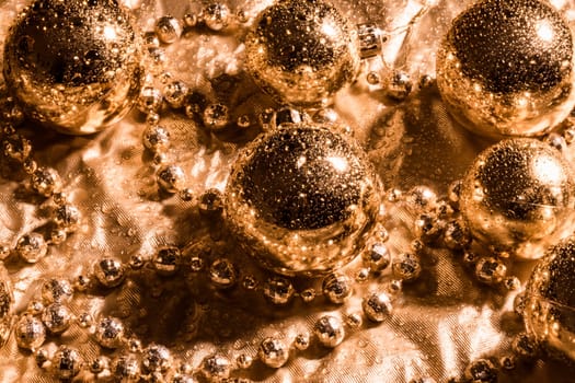 Golden Christmas decoration with water drops on golden background.