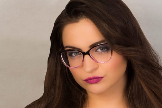 Beauty portrait of attractive woman with makeup and glasses.