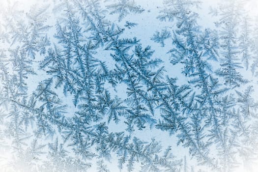 Macro photo of frozen ice crystals on glass as winter texture background.