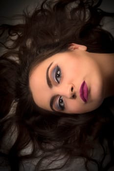 Lying female head with beautiful makeup and long hair.