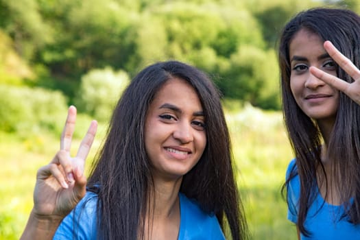 Women show victory signs - outdoor shot in summer