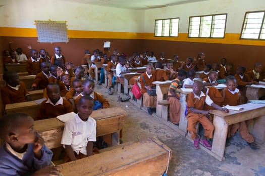 Arusha, Tanzania- Jan 26, 2015: Children in uniforms in elementary school classroom sitting behind desks listetning to teacher on January the 26th, rural area near Arusha, Tanzania, Africa.