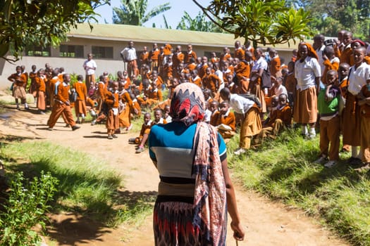 Arusha, Tanzania- Jan 26, 2015: Group of pupils in uniforms being disciplined by teacher in the cortyard of primary school on January the 26th, rural area near Arusha, Tanzania, Africa.