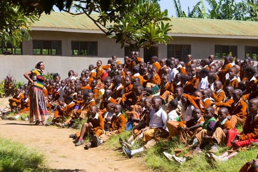 Arusha, Tanzania- Jan 26, 2015: Group of pupils in uniforms being disciplined by teacher in the cortyard of primary school on January the 26th, rural area near Arusha, Tanzania, Africa.