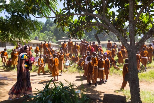 Arusha, Tanzania- Jan 26, 2015: Group of pupils in uniforms being disciplined by teacher in the cortyard of primary school on January the 26th, rural area near Arusha, Tanzania, Africa.