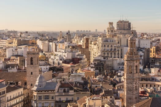 Aerial view of cityscape view on the old residential buildings with church tower in Valencia city during the sunny day in Spain.