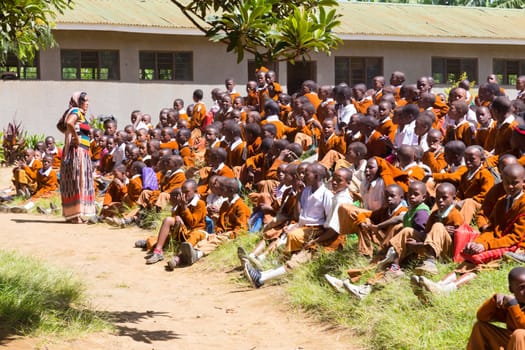 Arusha, Tanzania- Jan 26, 2015: Group of pupils in uniforms being disciplined by teacher in the cortyard of primary school on January the 26th, rural area near Arusha, Tanzania, Africa.