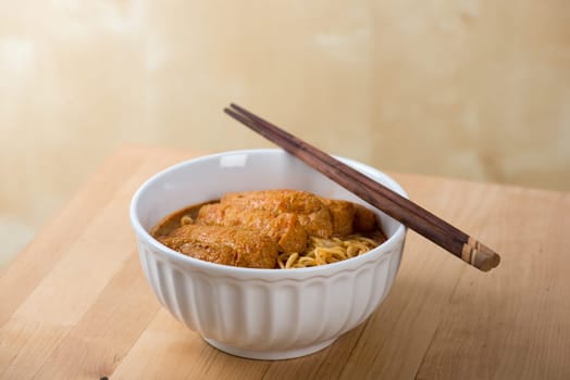 Curry laksa with chopsticks, a popular spicy dish in Malaysia cuisine.