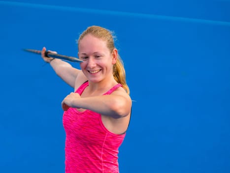 young woman throwing javelin in athletics