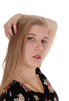 A beautiful young woman with long blond hair looking into the camera.with her hand on her head, isolated for white background.