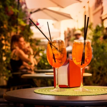 Aperol Spritz Cocktail. Alcoholic beverage based on table with ice cubes and oranges.