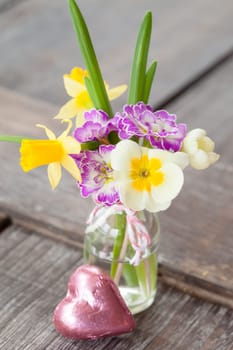 Colourful bouquet of spring flowers in a small bottle