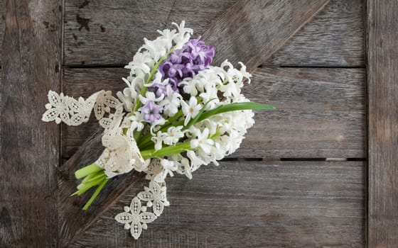 Small bouquet of fresh hyacinths on a rustic wooden background