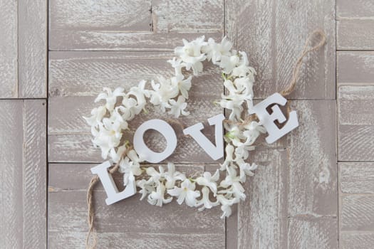 Heart of white blues on background of wood