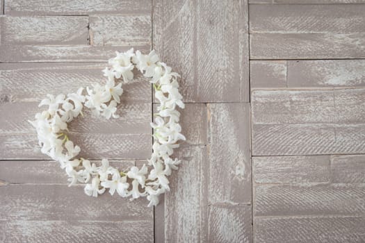 Heart of white blues on background of wood