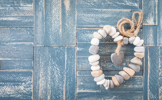 Heart of pebbles and rustic background of wood