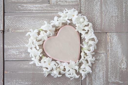 Heart of white blues on background of wood