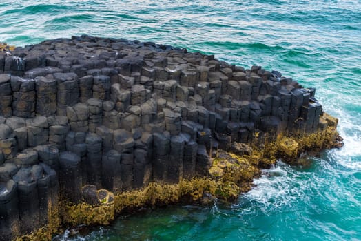 Crescent shaped hexagonal rock formations at Fingal Head, Australia