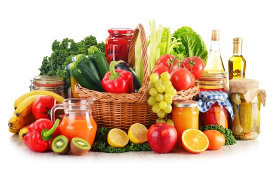 Composition with variety organic vegetables and fruits in wicker basket isolated on white
