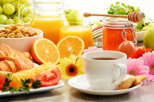 Breakfast consisting of fruits, orange juice, coffee, honey, bread and egg. Balanced diet
