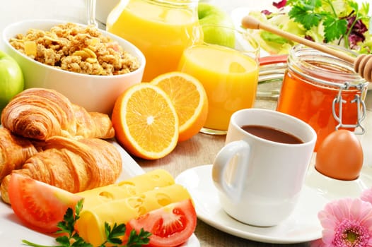Breakfast consisting of fruits, orange juice, coffee, honey, bread and egg. Balanced diet