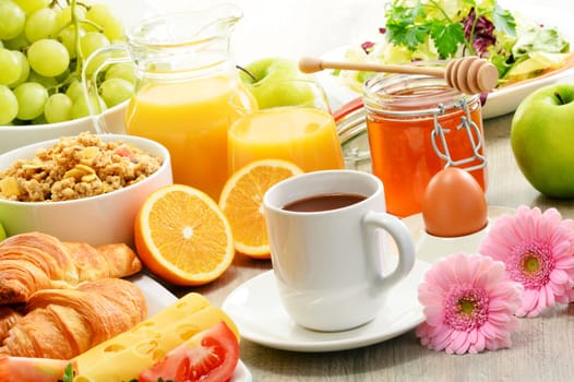 Breakfast consisting of fruits, orange juice, coffee, honey, bread and egg. Balanced diet