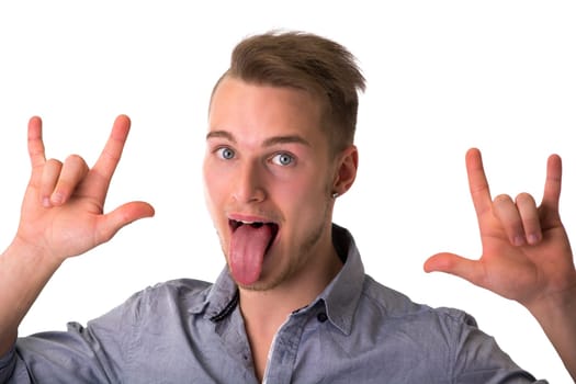 Happy handsome young man sticking out tongue and doing I Love You hand sign