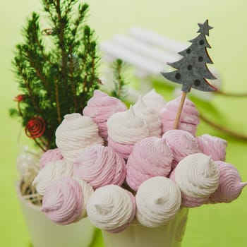Delicious sweet buffet with homemade pink and white zephyr. Russian marshmallows. On a green background, selective focus