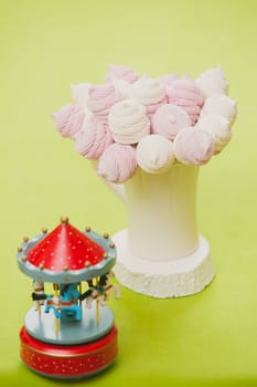 Delicious sweet buffet with homemade pink and white zephyr. Russian marshmallows. On a green background, selective focus