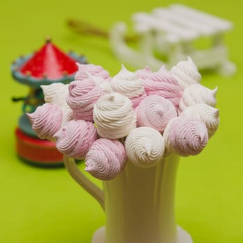 Delicious sweet buffet with homemade pink and white zephyr. Russian marshmallows. On a green background, selective focus