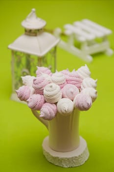 Delicious sweet buffet with homemade pink and white zephyr. Russian marshmallows. On a green background, selective focus