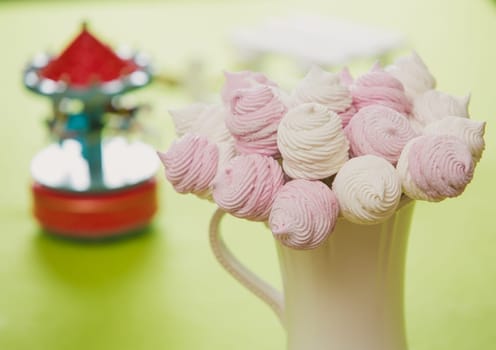 Delicious sweet buffet with homemade pink and white zephyr. Russian marshmallows. On a green background, selective focus