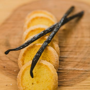 Fresh baked shortbread cookies with  with vanilla sticks on a wood, shalow D.O.F