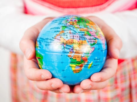 Hands of a child holding globe